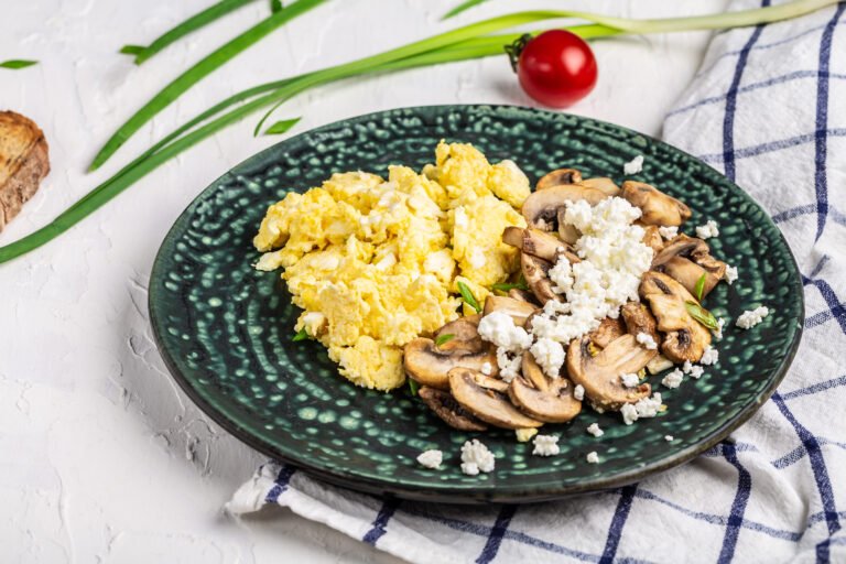 Close up of scrambled eggs with champignon mushrooms