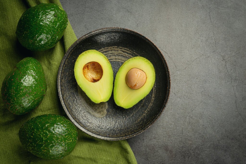 Some avocados on a frying pan and some on the floor