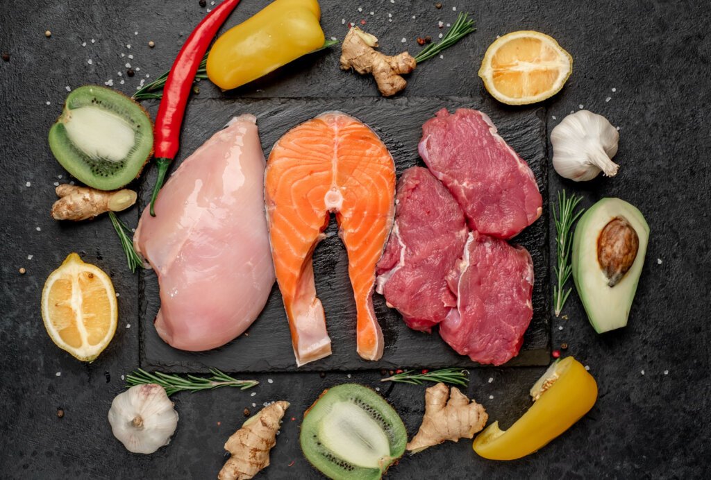 Lean mutton, fish and poultry surrounded by different types of veggies