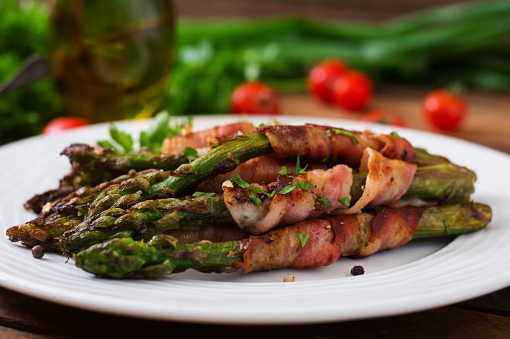 Air fryer bacon-wrapped asparagus On a white plate